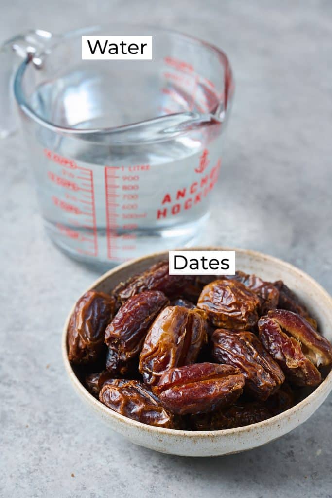 Ingredients needed to make date syrup displayed in glass measuring cup and bowl of medjool dates