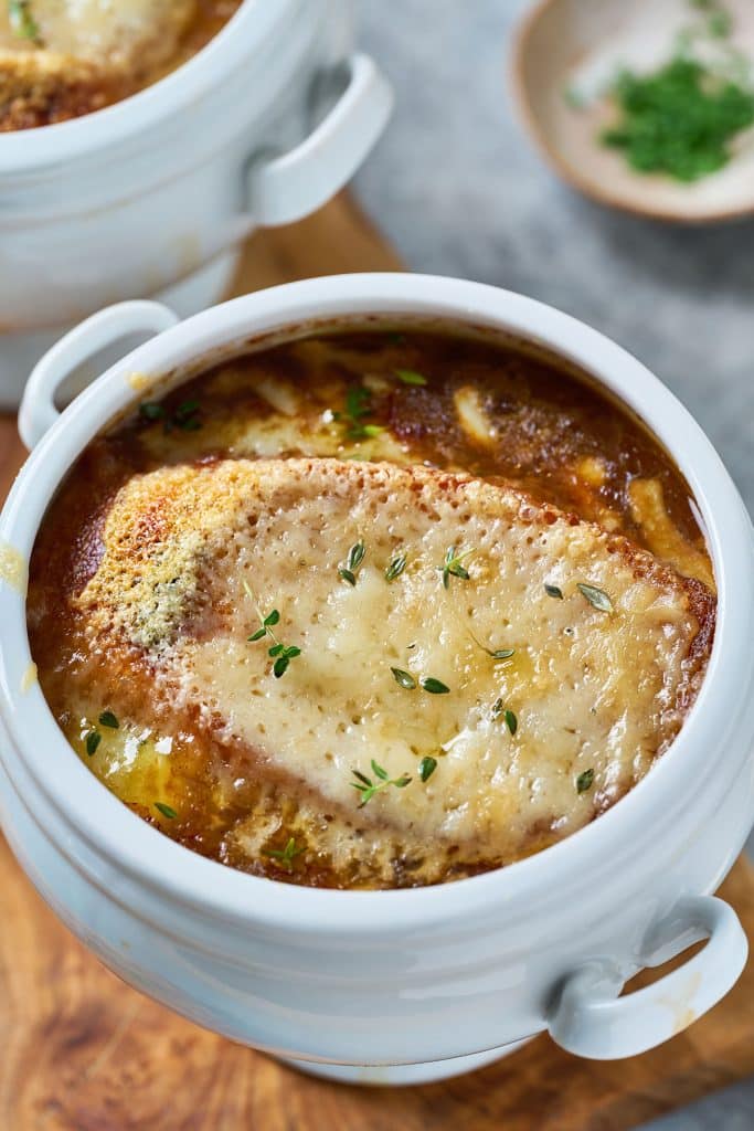 top view of a bowl of golden French onion soup topped with melted cheese on toasty bread.