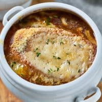 a bowl of French onion soup with cheesy bread topping