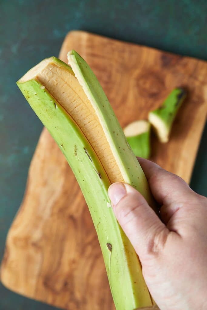 removing skin from a plantain after skin being cut lenghtwise