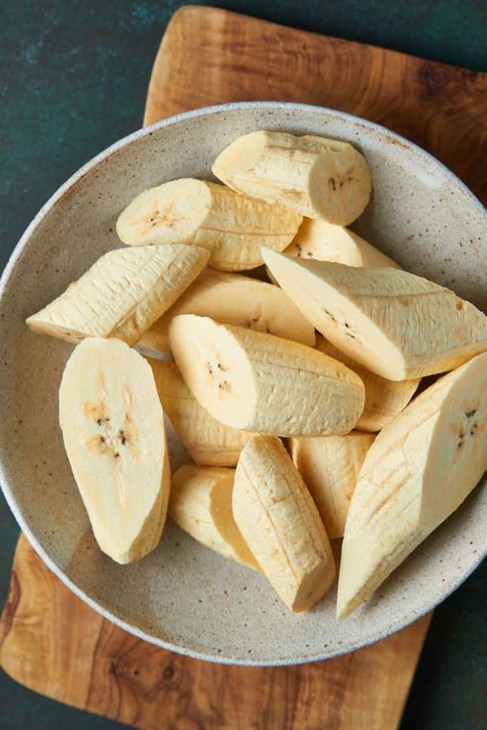 2 inch Plantain chunks placed into a bowl after being sliced diagonally.
