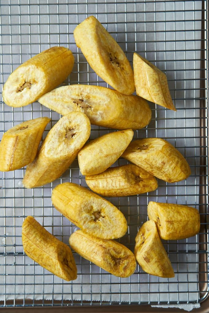 Golden yellow patacones placed on a cooling rack