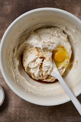 Egg and vanilla in a mixing bowl with dough.