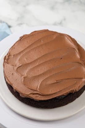 vegan chocolate buttercream spread on top of one layer of cake