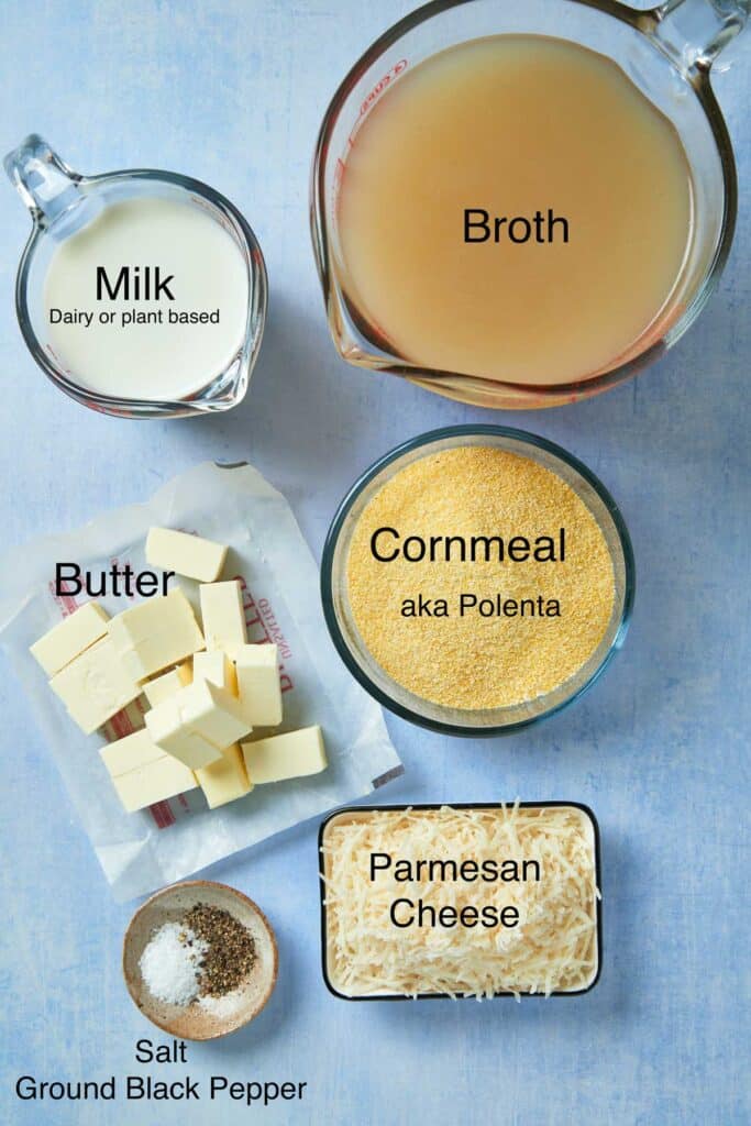 Ingredients to make creamy polenta on a blueish counter