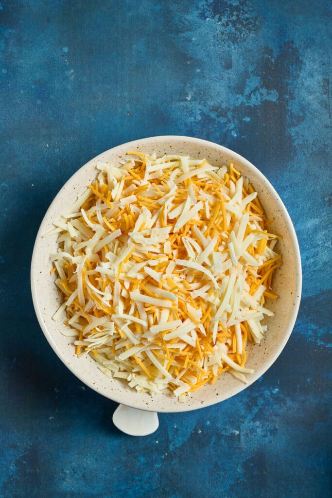 three types of shredded cheese in a bowl