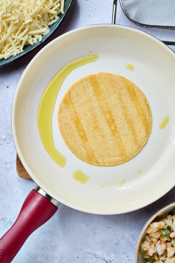 Crisping up a corn tortilla in a skillet
