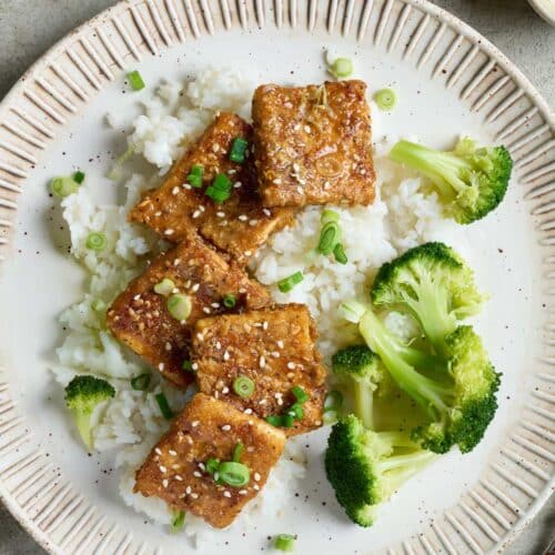 Crispy tofu with sesame seeds over rice with broccoli