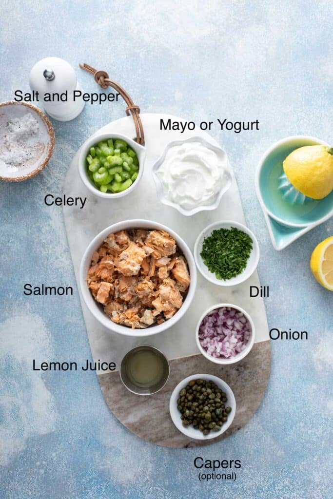 Ingredients to make canned salmon salad on a marble board