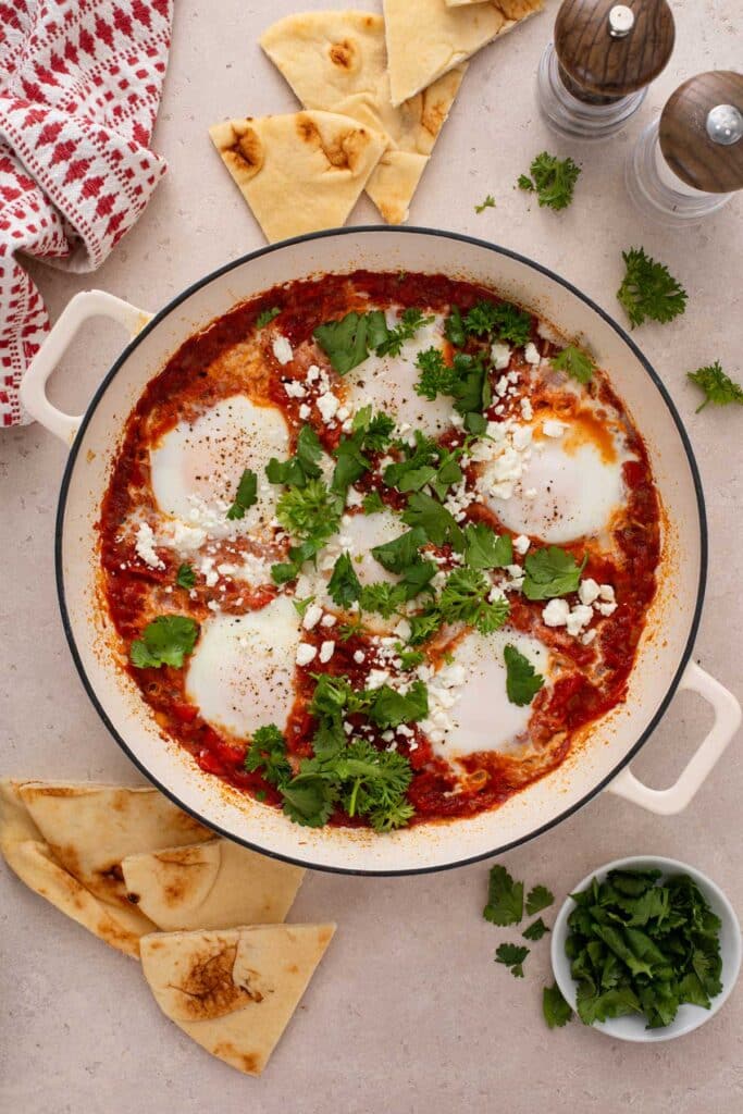 A skillet with eggs poached in tomato sauce.