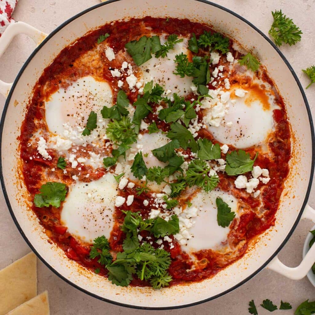 a pan of eggs poached in tomato sauce