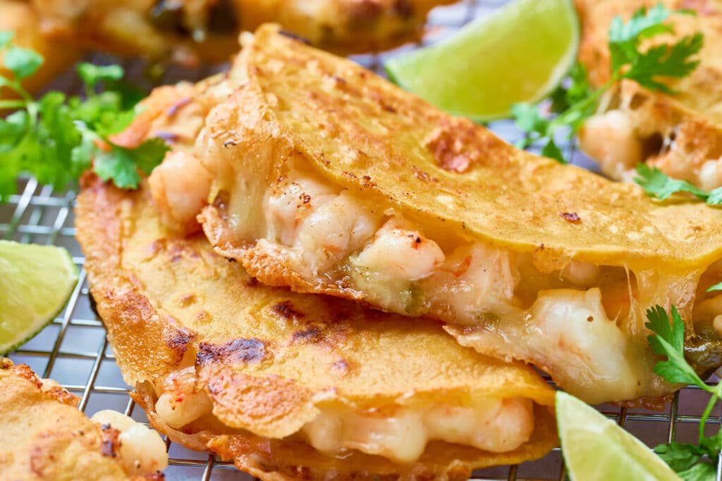 Golden brown, crispy and cheesy shrimp tacos on a rack.