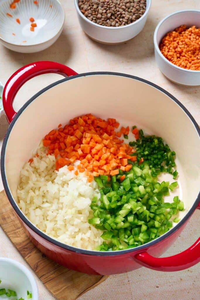 Chopped carrots, onion, bell pepper and jalapeño sautéing in a Dutch oven