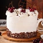 a whole Black Forest Cake with whipped cream frosting and cherries on top