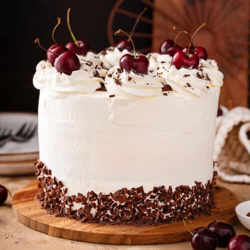 a whole Black Forest Cake with whipped cream frosting and cherries on top