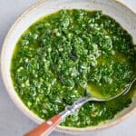 A bowl filled with a herby garlicky sauce called chimichurri