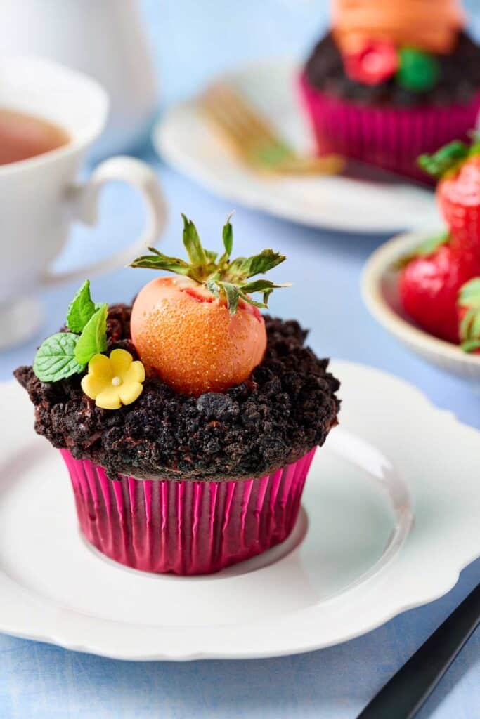 Chocolate easter cupcakes with oreo dirt and candy coated strawberry plus candy flower