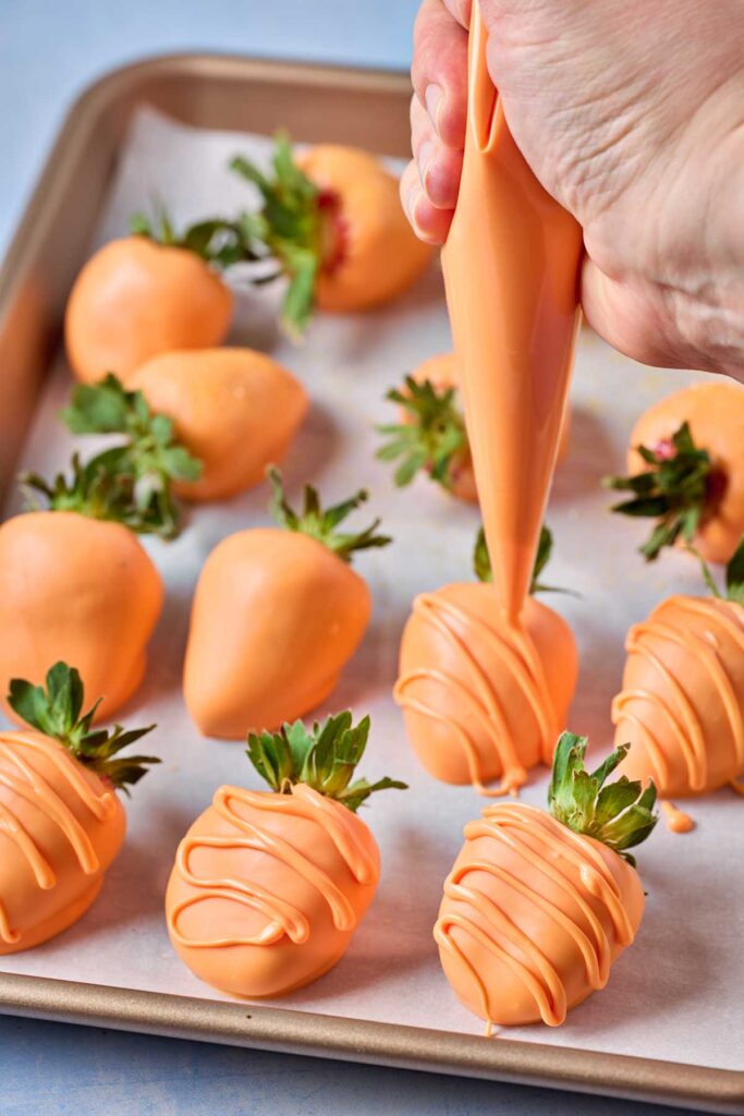 Piping decorations on a covered strawberry