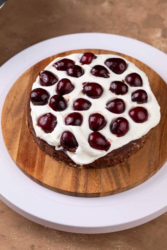 One layer of cake covered with whipped cream and topped with fresh cherries