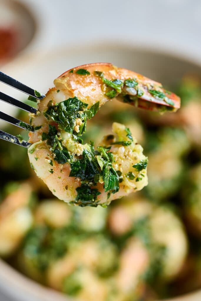close up view of a sautéed shrimp covered in chimichurri