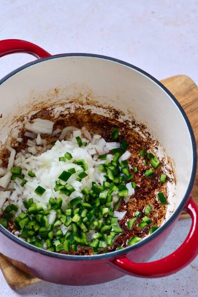 Chopped onions and jalapeño sautéing in bacon fat