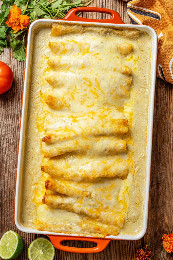 Baked creamy and cheesy enchiladas in a baking pan