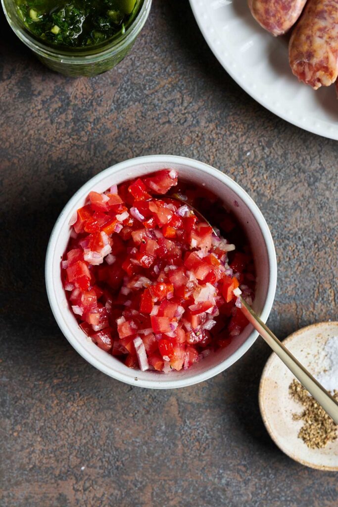 A small bowl with a tomato and onion salsa.