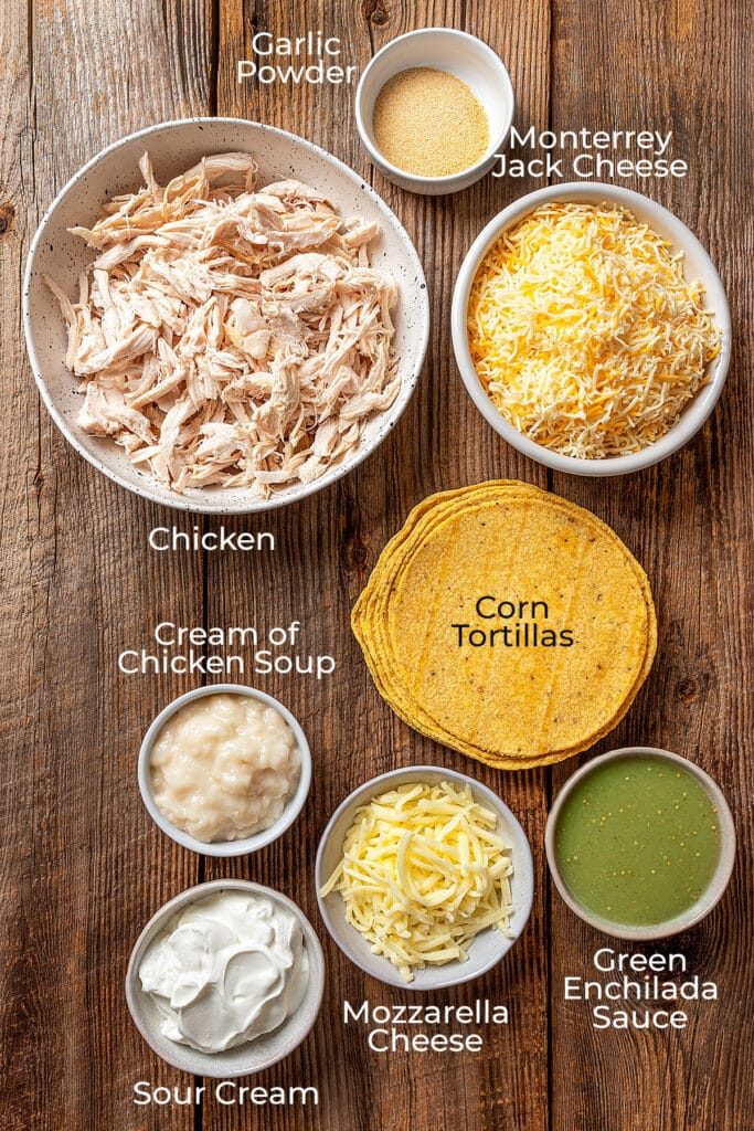 Ingredients to make chicken enchilada casserole on a wooden surface