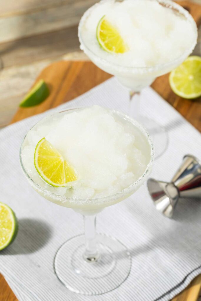 Frozen margarita served in a salt-rimmed glass with lime garnish.