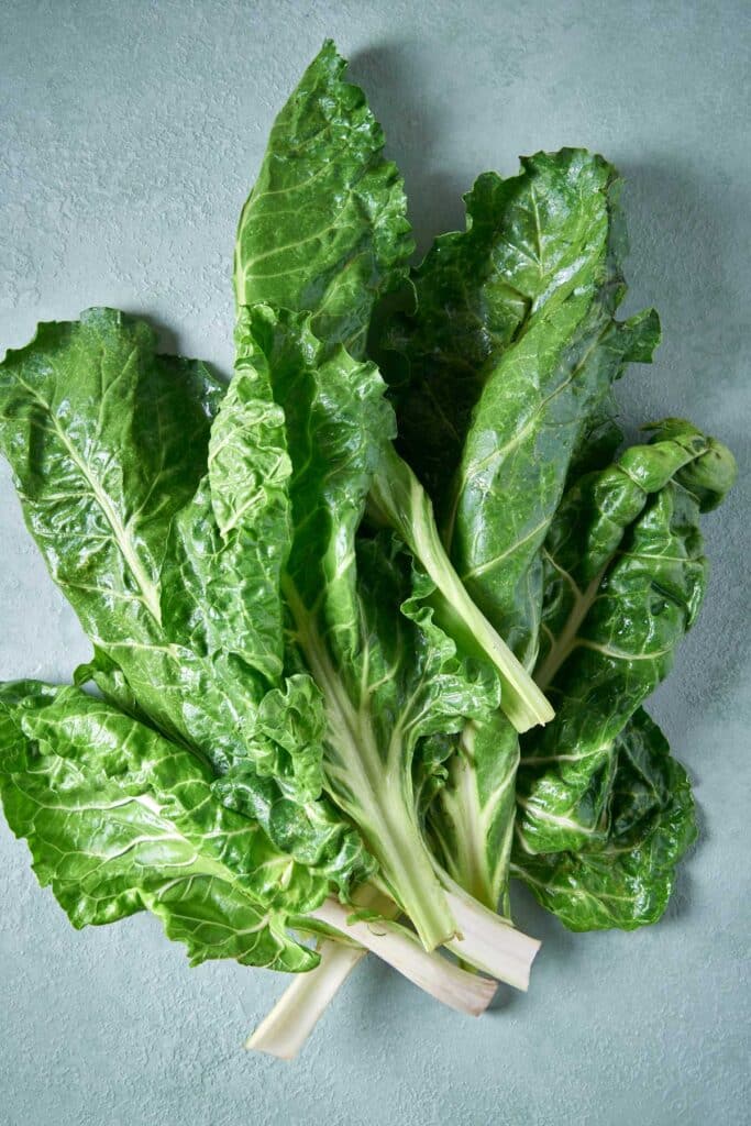 A loose bunch of Swiss chard with green leaves and white stems