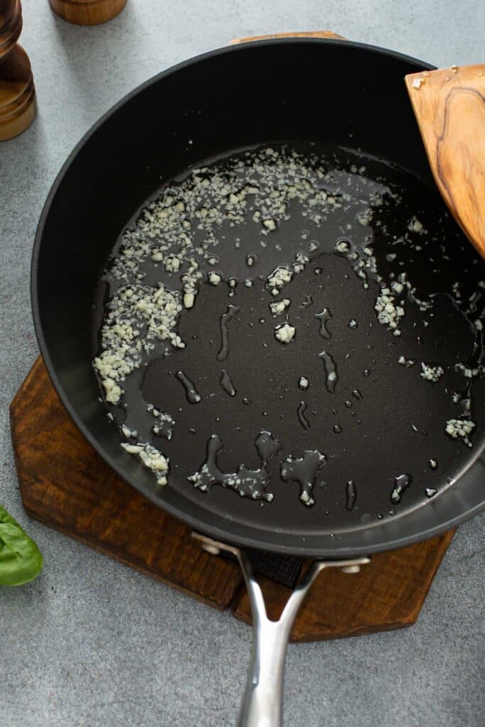 A skillet with oil and minced garlic
