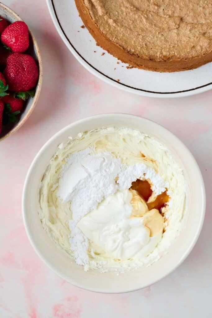 Cream cheese frosting ingredients in a bowl ready to be whipped