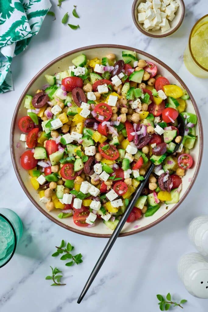 A bowl filled with colorful chopped Mediterranean chickpea salad