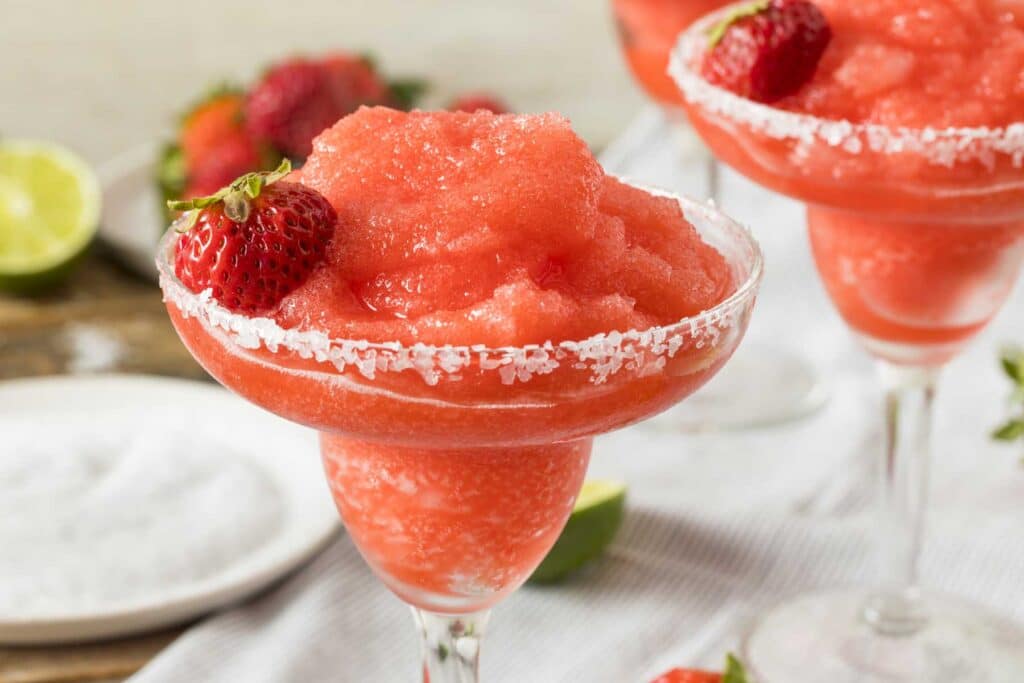 Salt-rimmed glasses with frozen strawberry margarita