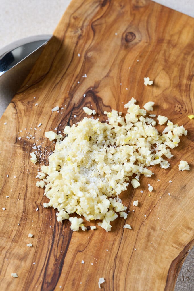 Minced garlic with salt on a cutting board