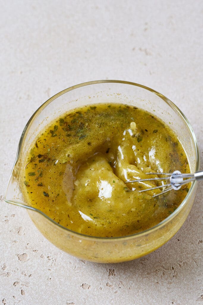 Whisking mojo sauce in a glass container