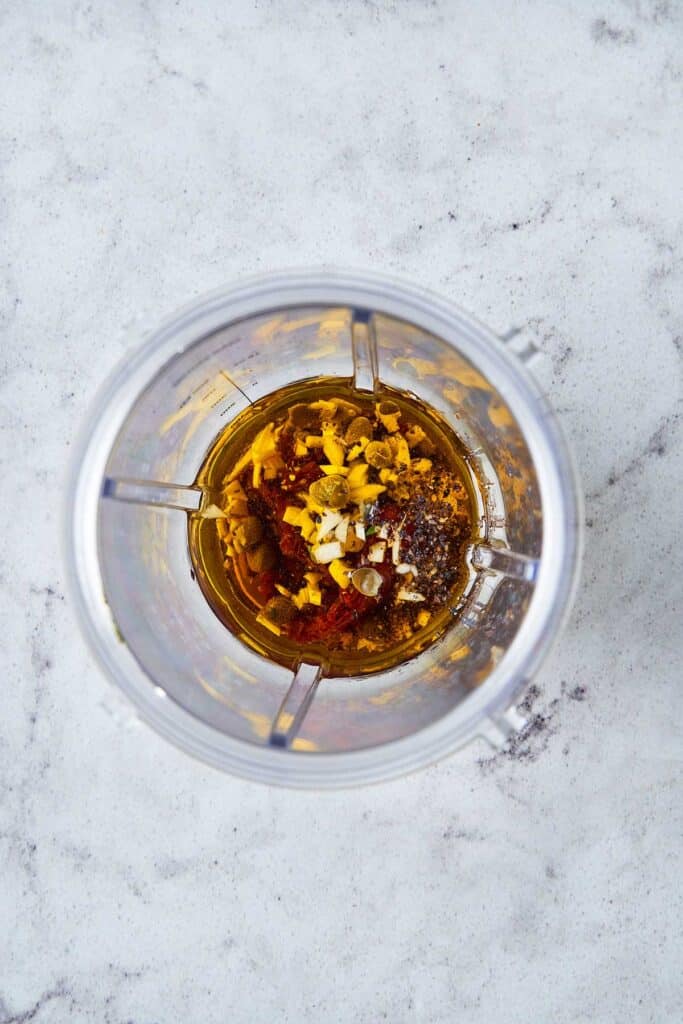 A small blender processing pasta salad vinaigrette ingredients