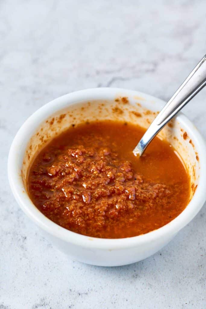 Sun-dried tomato vinaigrette in a small white bowl