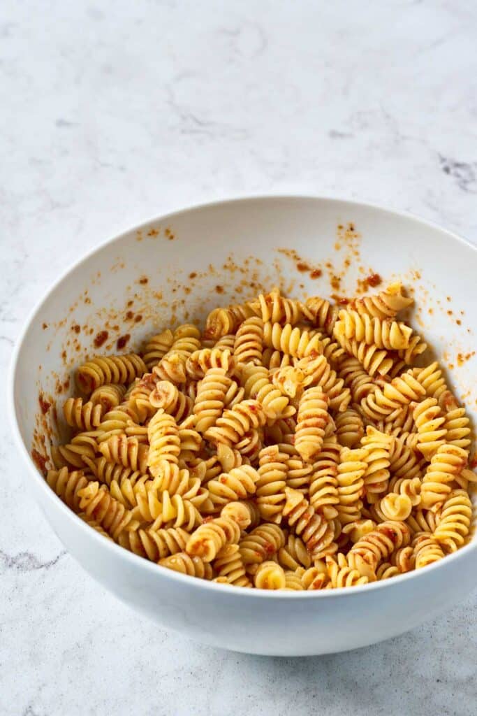 a bowl with pasta tossed with sun-dried tomato vinaigrette