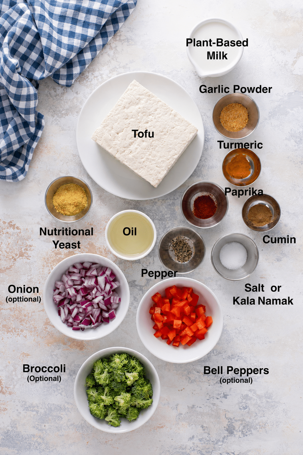 Ingredients for tofu scramble with firm tofu, plant milk, seasonings and optional vegetables